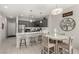 Modern kitchen and dining area with stainless steel appliances, gray cabinetry, and a breakfast bar at 703 Sleeping City Ave, Henderson, NV 89015