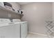 A conveniently located laundry room with a washer, dryer, storage shelf, and drying rack at 703 Sleeping City Ave, Henderson, NV 89015
