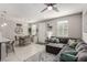 Bright living room featuring a large sectional sofa, dining table, and tile flooring at 703 Sleeping City Ave, Henderson, NV 89015