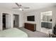 Comfortable main bedroom with modern ceiling fan, and large TV, with an ensuite bathroom at 703 Sleeping City Ave, Henderson, NV 89015