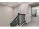 Upper landing with carpeted stairs, gray walls, and gray railings, leading to a bedroom at 703 Sleeping City Ave, Henderson, NV 89015
