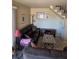 Cozy living room with black leather sofa, patterned rug, and staircase access at 741 Bourbon St # E3, Pahrump, NV 89048