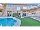 Backyard view shows a pool, synthetic grass, and covered patio with shade at 7520 Jacaranda Bay St, Las Vegas, NV 89139