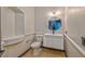 Bright bathroom features a built-in shelf, vanity, toilet, mirror and neutral tile flooring at 7520 Jacaranda Bay St, Las Vegas, NV 89139