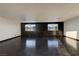Spacious living room featuring gleaming hardwood floors and plenty of natural light from two large windows at 7520 Jacaranda Bay St, Las Vegas, NV 89139