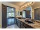 Spacious main bathroom with granite counters, dual sinks and vanity with views into bedroom at 7520 Jacaranda Bay St, Las Vegas, NV 89139