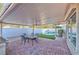 Covered patio features brick pavers, seating, and a view of the pool and well-manicured yard at 7520 Jacaranda Bay St, Las Vegas, NV 89139