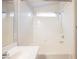 Clean bathroom with shower-tub combination, tiled walls, and window at 7620 Whispering River St, Las Vegas, NV 89131