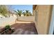 View of backyard with stone covered ground and a wooden table, surrounded by greenery and walls at 836 Sheerwater Ave, Henderson, NV 89052