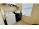 Functional laundry room featuring a white washer and black dryer, with ample shelving for storage at 836 Sheerwater Ave, Henderson, NV 89052
