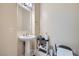 A quaint powder room offers a pedestal sink and updated fixtures at 92 Tesla Ridge Way, Las Vegas, NV 89183