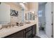 A renovated bathroom offers dual sinks, stone countertops, and ample storage space at 92 Tesla Ridge Way, Las Vegas, NV 89183