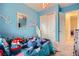 A bedroom with blue walls features a closet, a mirror, and bright overhead lighting at 92 Tesla Ridge Way, Las Vegas, NV 89183