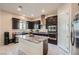 Modern kitchen featuring dark cabinets, granite countertops, stainless steel appliances, and a center island at 92 Tesla Ridge Way, Las Vegas, NV 89183