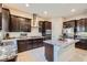 Modern kitchen featuring dark cabinetry, stainless steel appliances, and a center island with granite countertops at 92 Tesla Ridge Way, Las Vegas, NV 89183