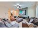 Open-concept living room with tile flooring, fireplace, large sectional sofa and plenty of natural light at 92 Tesla Ridge Way, Las Vegas, NV 89183