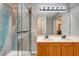 Bathroom featuring a double sink vanity and a walk-in shower with decorative accent wall at 9292 Vervain Ct, Las Vegas, NV 89149