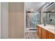 Modern bathroom featuring a glass-enclosed shower and a double vanity sink with wood cabinets at 9292 Vervain Ct, Las Vegas, NV 89149