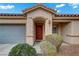 Front view of a charming home with a two-car garage, arched entryway, and well-maintained landscaping at 9292 Vervain Ct, Las Vegas, NV 89149
