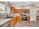 Charming kitchen with wood cabinets, stainless steel dishwasher, and stylish faucet at 9292 Vervain Ct, Las Vegas, NV 89149
