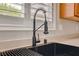 Modern kitchen sink with a matte black faucet and bright natural light through window at 9292 Vervain Ct, Las Vegas, NV 89149