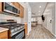 Open kitchen view with stainless steel appliances, wood cabinets, and sight into the living room at 9292 Vervain Ct, Las Vegas, NV 89149
