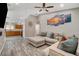 Open-concept living room with a comfortable sectional sofa, ceiling fan, and decorative wall art at 9292 Vervain Ct, Las Vegas, NV 89149