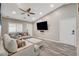 Spacious living room with a modern sectional, ceiling fan, and a mounted flat-screen television at 9292 Vervain Ct, Las Vegas, NV 89149
