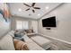 Comfortable living room with a sectional couch, ceiling fan, and a large screen TV mounted on the wall at 9292 Vervain Ct, Las Vegas, NV 89149
