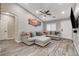 Bright living room with a comfortable sectional sofa, ceiling fan, and modern wall decor at 9292 Vervain Ct, Las Vegas, NV 89149