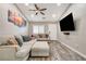 Open living area featuring a large sectional sofa, ceiling fan, and mounted TV at 9292 Vervain Ct, Las Vegas, NV 89149