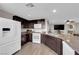 Well-lit kitchen with dark cabinetry, granite countertops, and stainless steel appliances at 958 Harbor Ave, Henderson, NV 89002