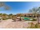Beautiful backyard featuring desert landscaping, brick pavers, and a swimming pool surrounded by artificial turf at 9816 Gerald Ct, Las Vegas, NV 89134