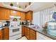 Traditional kitchen boasts wood cabinets, granite countertops, and white appliances at 1455 E Katie Ave # A21, Las Vegas, NV 89119