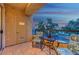 Comfortable balcony furniture on a tiled surface, with a sunset view and some trees obscuring a hotel or condo building at 210 E Flamingo Rd # 326, Las Vegas, NV 89169