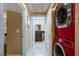 Hallway features a side-by-side red washer and dryer, with a view to a bathroom and a bedroom behind an open door at 210 E Flamingo Rd # 326, Las Vegas, NV 89169