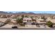 Aerial view of a desert community home with a tile roof, extended driveway, and mountain backdrop at 2199 Maple Shade St, Henderson, NV 89002