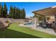 Private backyard oasis with a sparkling pool, lush lawn, and outdoor seating areas at 2199 Maple Shade St, Henderson, NV 89002