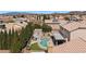 Enjoy a private backyard oasis featuring a sparkling pool, lush greenery, and a cozy seating area at 2199 Maple Shade St, Henderson, NV 89002