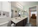 Well-lit bathroom with a double vanity, large mirror, and a peek into an adjacent bedroom at 2199 Maple Shade St, Henderson, NV 89002
