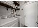 Bright laundry room featuring a modern washer and dryer, rustic shelves, and charming decor at 2199 Maple Shade St, Henderson, NV 89002