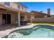 Backyard pool area with seating steps, an outdoor kitchen, and a covered patio at 2199 Maple Shade St, Henderson, NV 89002