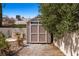 View of the backyard shed with neutral paint, white trim and door, and gravel base at 2199 Maple Shade St, Henderson, NV 89002