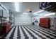 Spacious garage with ample lighting, custom cabinets, tool storage, and stylish checkered flooring at 2514 Spergola St, Henderson, NV 89044