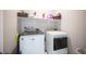 Efficient laundry area with modern washer and dryer, with extra storage shelves above for organizing supplies at 2514 Spergola St, Henderson, NV 89044
