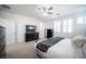 Bright main bedroom with modern ceiling fan, light gray walls, and dresser with television at 2514 Spergola St, Henderson, NV 89044