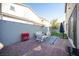 Charming patio area, with pavers, a lounging sofa, an outdoor umbrella, and artificial grass at 2514 Spergola St, Henderson, NV 89044