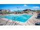 A sparkling community pool with lounge chairs and shade umbrellas on a sunny day at 2514 Spergola St, Henderson, NV 89044