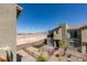 Backyard view featuring desert landscaping with mountain views, a small grassy area, and two-story townhomes at 2598 Mocha Pearl Ct, North Las Vegas, NV 89086