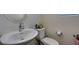 Bathroom featuring a white sink, toilet, and a round mirror at 2598 Mocha Pearl Ct, North Las Vegas, NV 89086